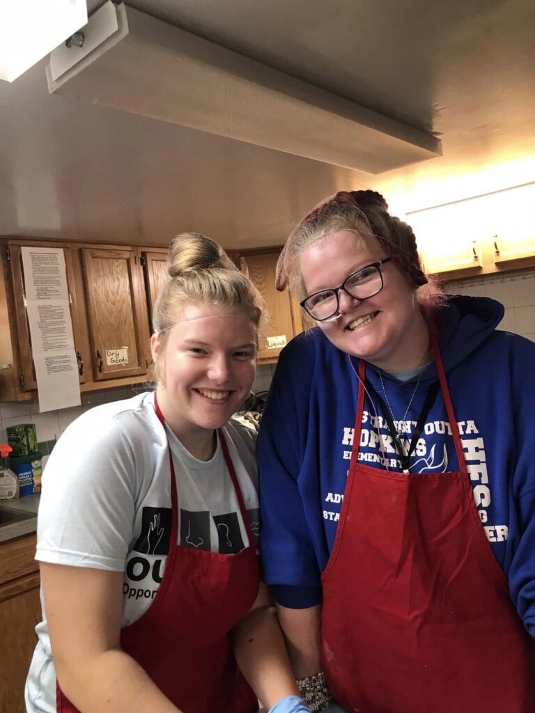 Two smiling staff members in the kitchen