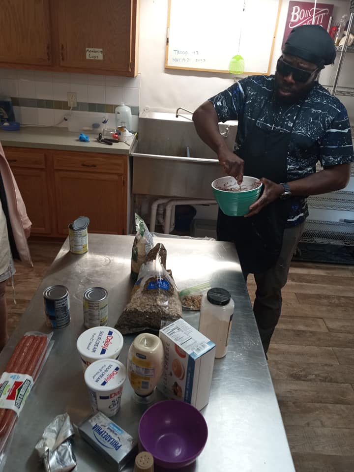 A camper mixes some ingredients in the kitchen