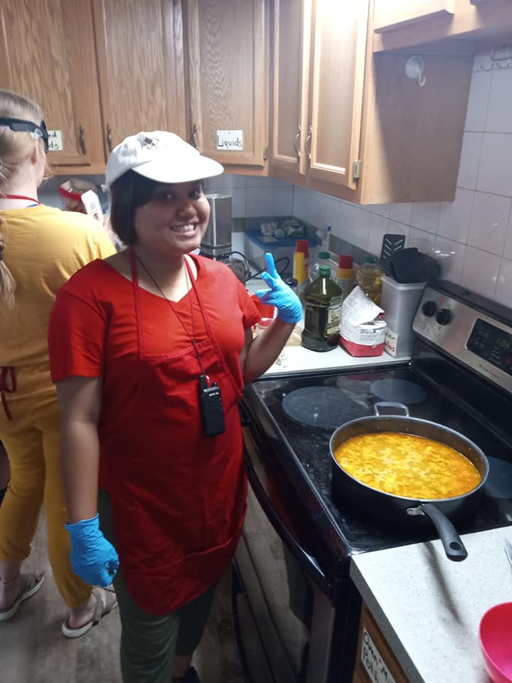 A camper poses with her simmering creation in the kitchen