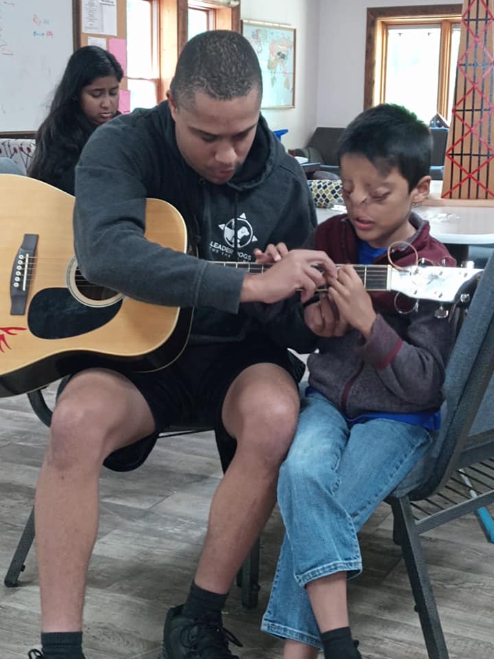 camper and counselor get musical with a guitar