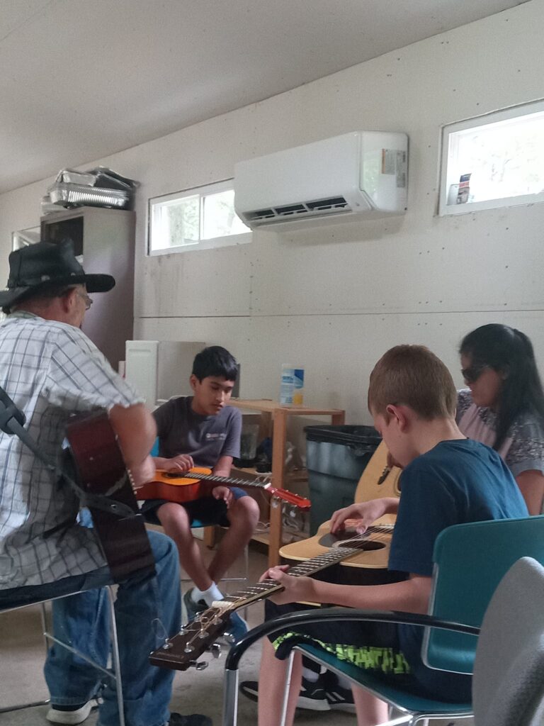 Some campers getting introduced to the guitar