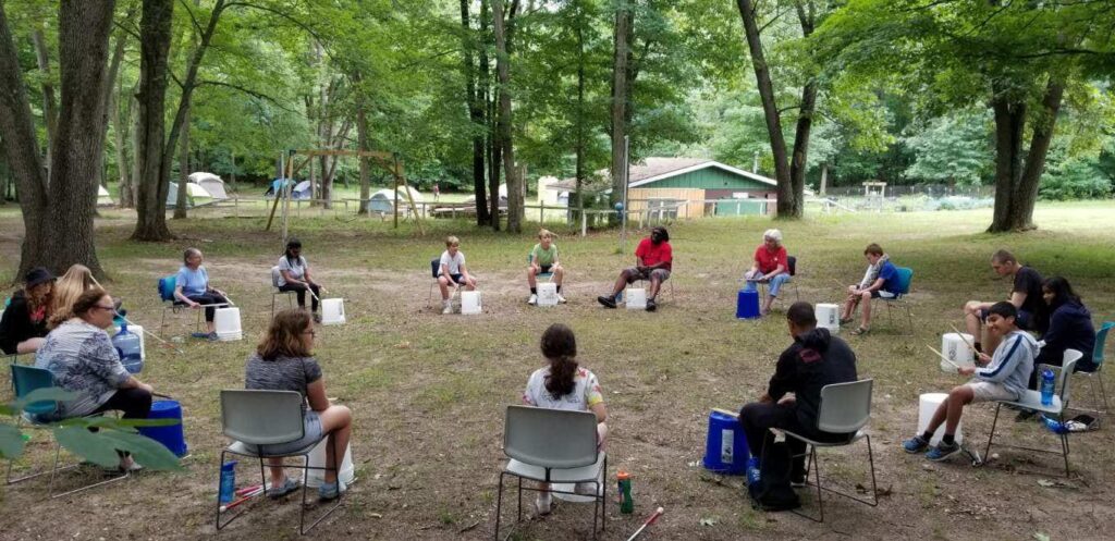 Some campers do some bucket drumming outside